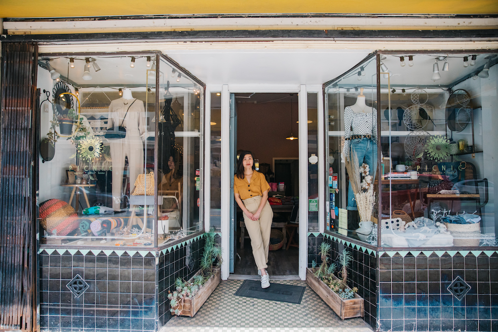 A small business owner stands in the doorway of her brick and mortar location